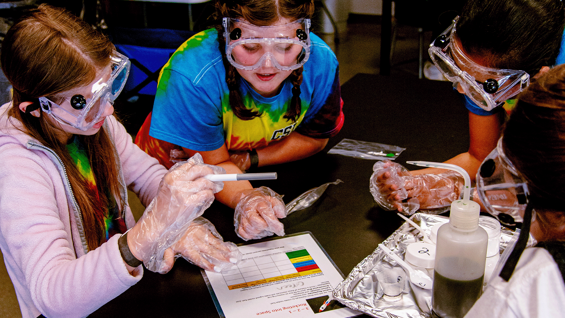 Teenagers work together to complete a science experiment