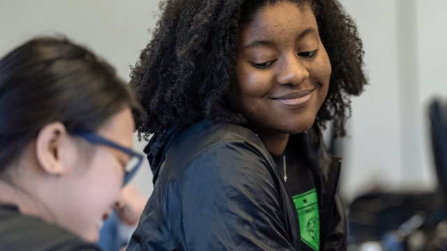 Trainees smile as they find the solution to a bug in the programming