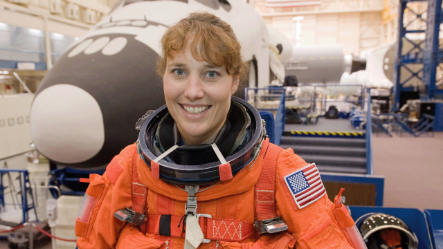 NASA astronaut Dorothy Metcalf-Lindenburger, STS-131 mission specialist, attired in a training version of her shuttle launch and entry suit, poses for a photo prior to the start of an ingress/egress training session in the Space Vehicle Mock-up Facility
