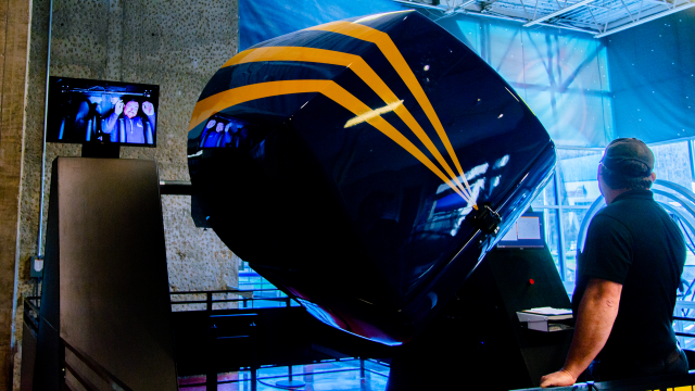 The MaxFlight capsule is tilted off center axis. A screen shows the rider inside with their hands up gleefully