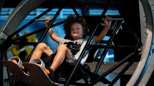 A trainees hair is tossed up as they are spun inside the Multi-Axis Trainer