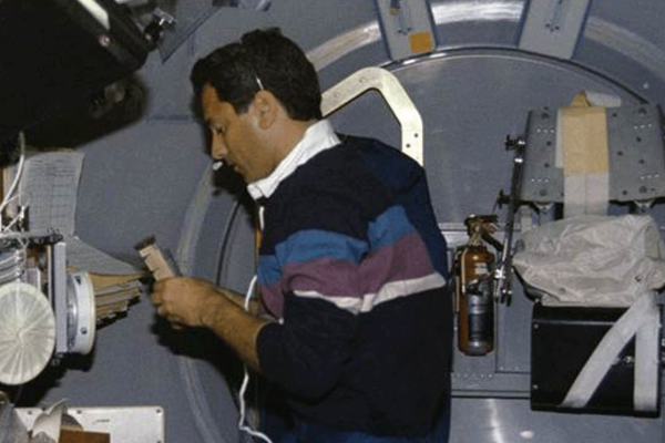 Astronaut Larry DeLucas, payload specialist, handles a Protein Crystal Growth (PCG) sample at the multipurpose glovebox aboard the Earth-orbiting space shuttle Columbia. (NASA)