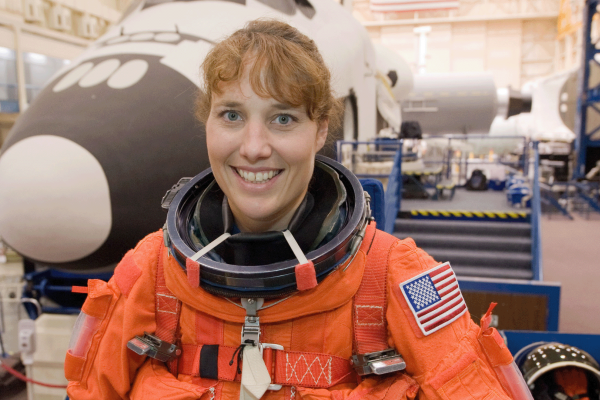 NASA astronaut Dorothy Metcalf-Lindenburger, STS-131 mission specialist, attired in a training version of her shuttle launch and entry suit, poses for a photo prior to the start of an ingress/egress training session in the Space Vehicle Mock-up Facility