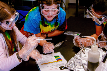 Teenagers work together to complete a science experiment